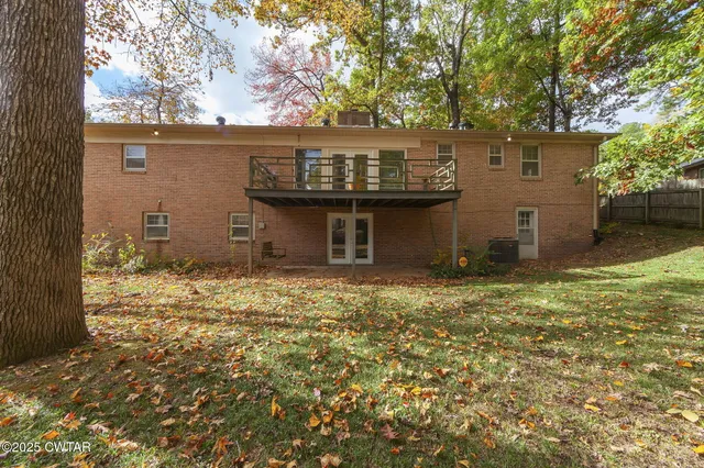front view of a house with a large tree