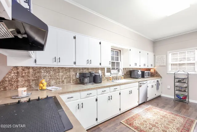 a kitchen with stainless steel appliances white cabinets and a sink
