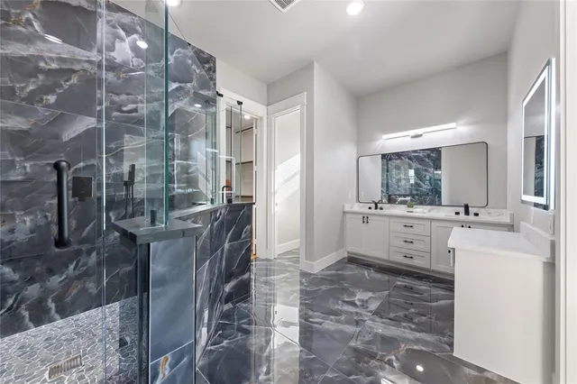 a bathroom with a double vanity sink a mirror and a shower