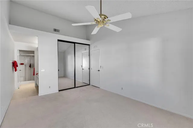 an empty room with fan and entryway