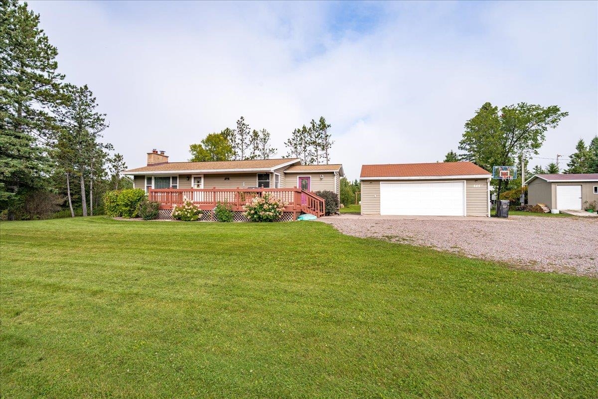 645 Stanley Road Two Harbors, MN 55616 - Photo 18 of 26 Single story home with a wooden deck, a garage, an outdoor structure, a front lawn, and a chimney