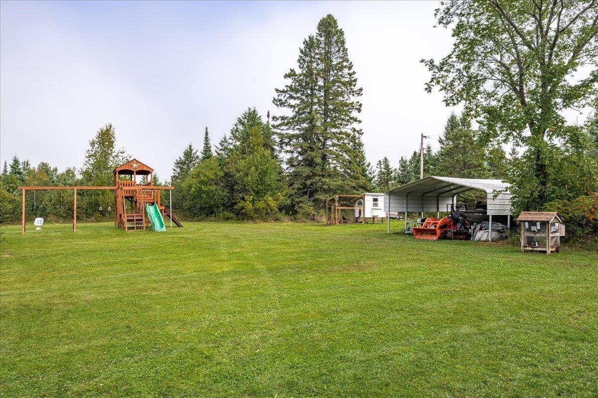 645 Stanley Road Two Harbors, MN 55616 - Photo 21 of 26 View of grassy yard featuring a playground and a detached carport
