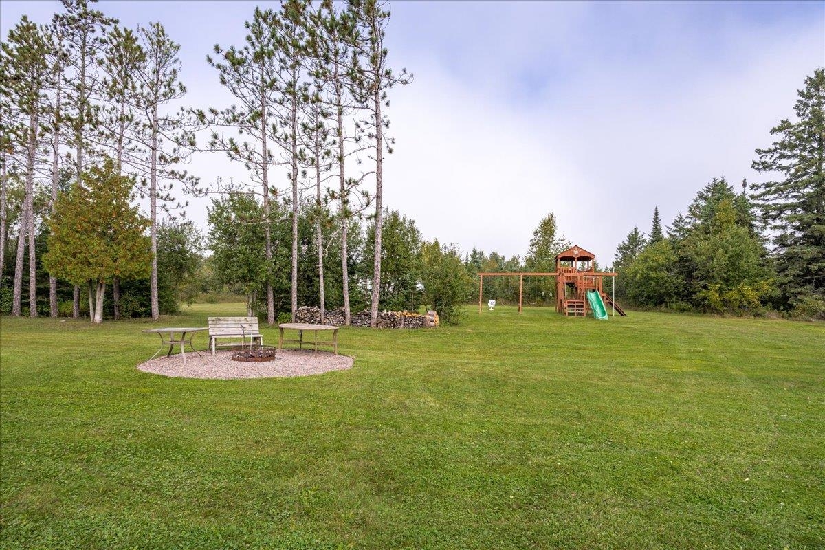 645 Stanley Road Two Harbors, MN 55616 - Photo 22 of 26 View of grassy yard featuring a playground and an outdoor fire pit