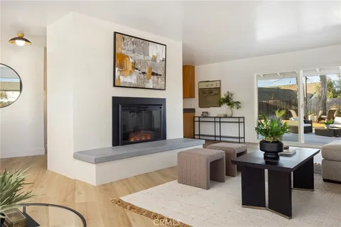 a living room with furniture a fireplace and a floor to ceiling window