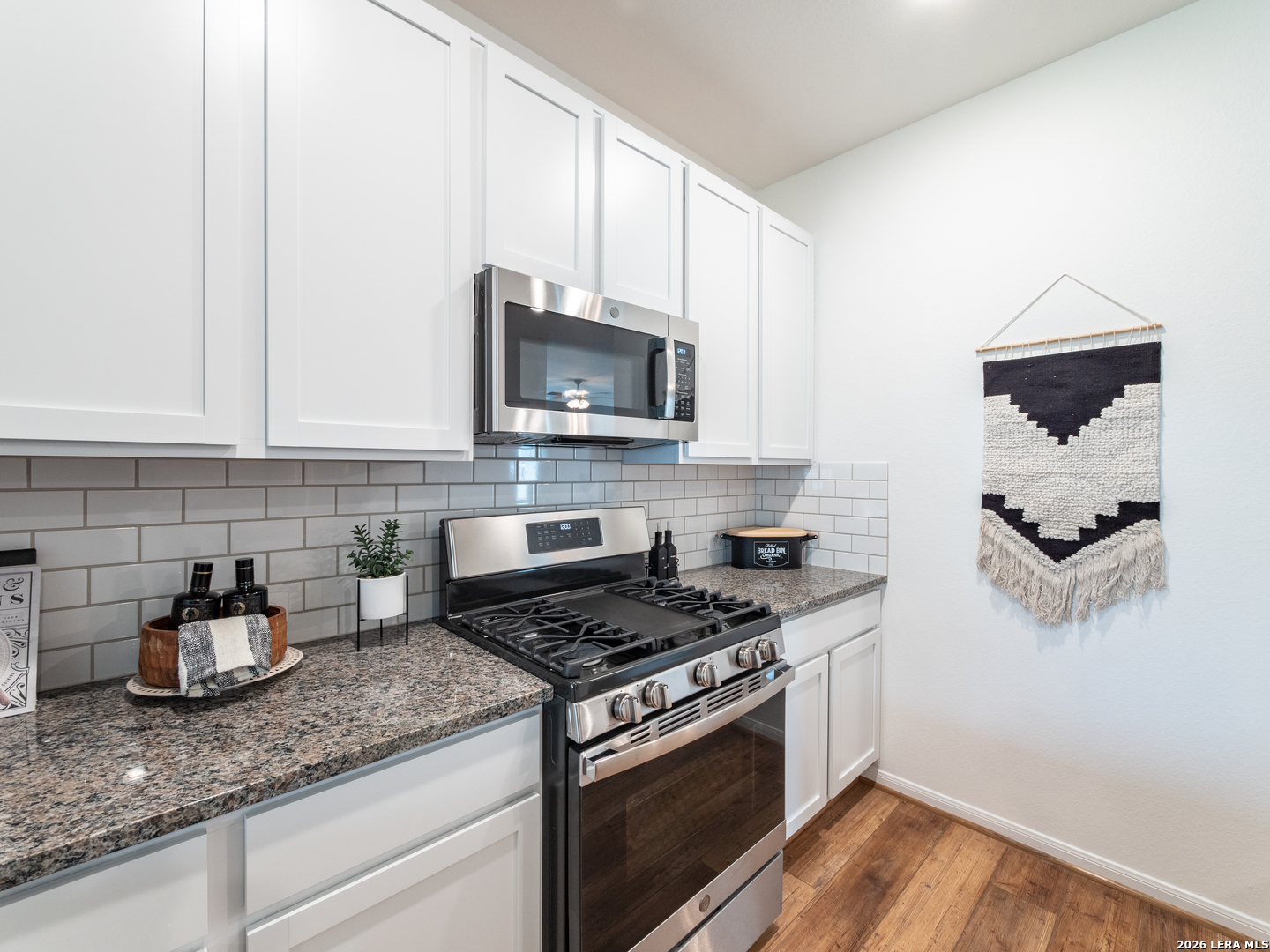 10715 Upwind Turn Converse, TX 78109 - Photo 8 of 17 a kitchen with granite countertop cabinets stainless steel appliances and wooden floor