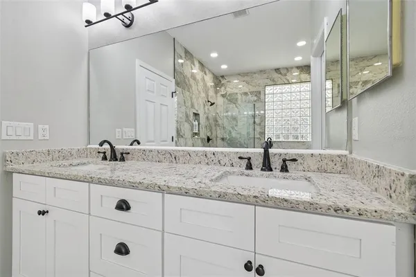 a bathroom with double sink and a mirror