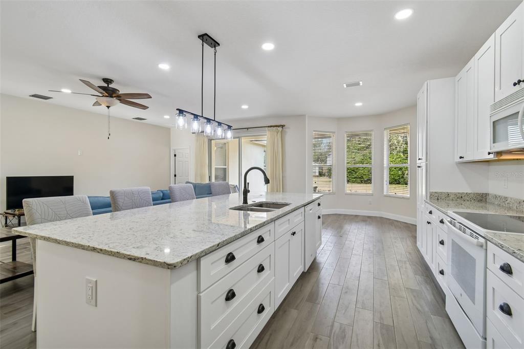 3311 Stonebridge Trail Valrico, FL 33596 - Photo 9 of 33 a large kitchen with kitchen island a stove a sink a center island and wooden floor