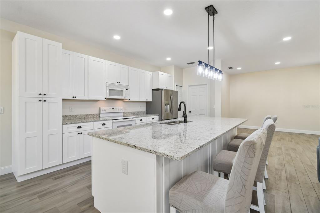 3311 Stonebridge Trail Valrico, FL 33596 - Photo 10 of 33 a kitchen with a sink stools a counter space and cabinets