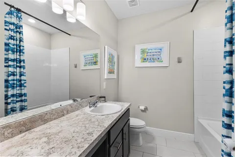 a bathroom with a granite countertop sink a mirror and a toilet
