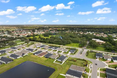 an aerial view of a city with lots of residential buildings ocean and mountain view in back