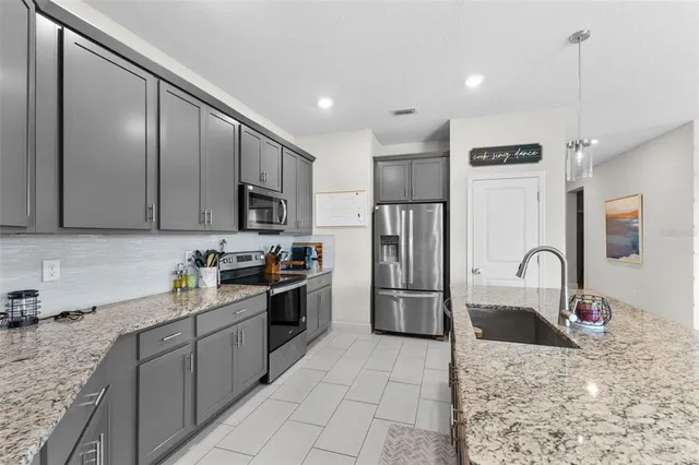 a kitchen with stainless steel appliances granite countertop a sink refrigerator and microwave