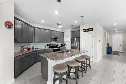 a kitchen with kitchen island granite countertop a sink and cabinets