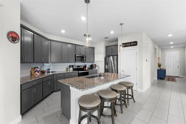 a kitchen with kitchen island granite countertop a sink and cabinets