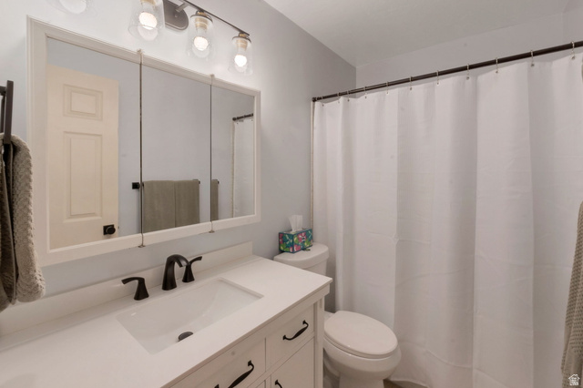 11072 Windy Peak Ridge Drive, Unit 32 Sandy, UT 84094 - Photo 21 of 30 Bathroom featuring a white vanity with an integrated sink, dark bronze faucet, and black hardware