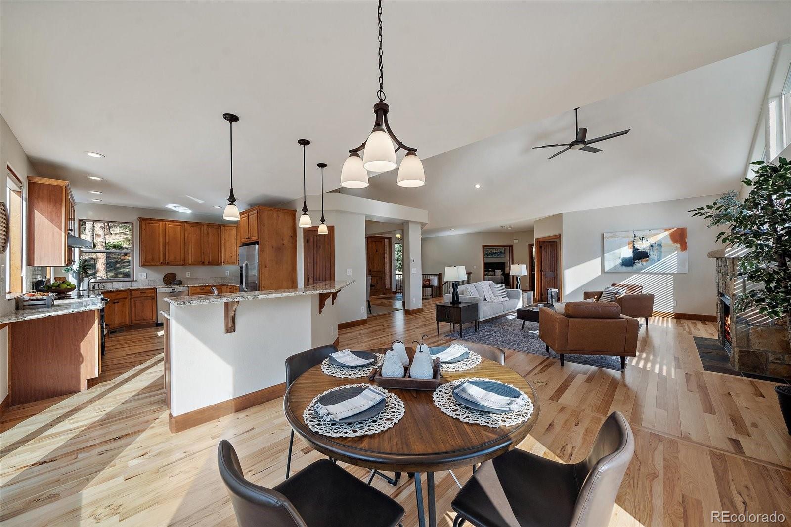 28857 Cedar Circle Evergreen, CO 80439 - Photo 15 of 50 a view of a dining room and livingroom with furniture wooden floor a chandelier