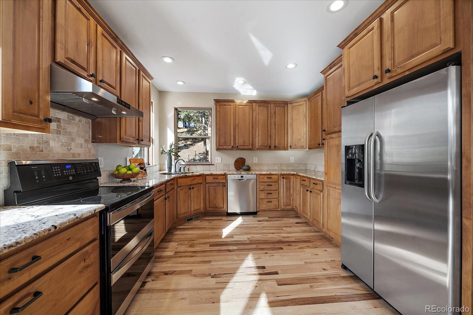 28857 Cedar Circle Evergreen, CO 80439 - Photo 18 of 50 a kitchen with stainless steel appliances granite countertop a refrigerator a stove and a sink