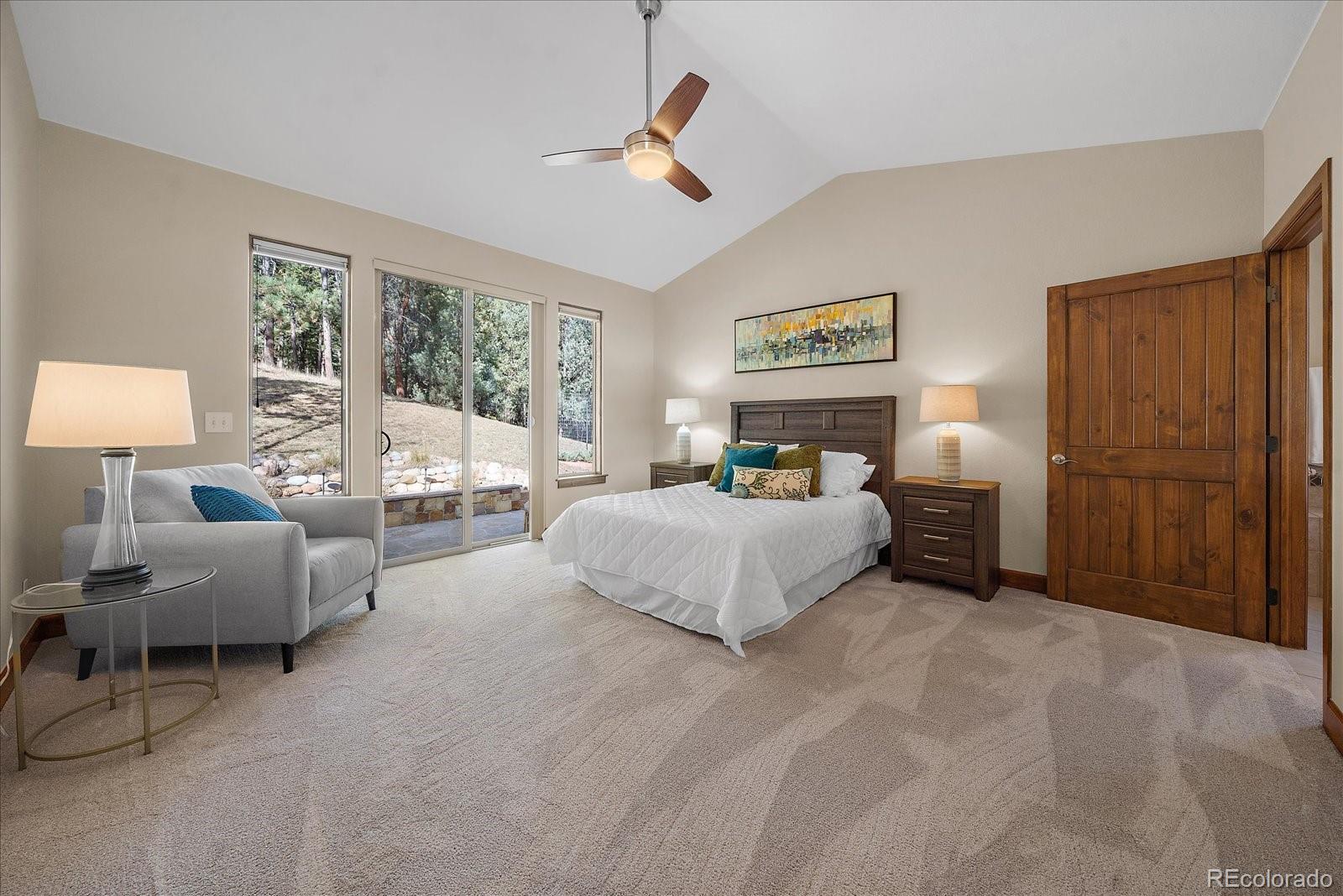 28857 Cedar Circle Evergreen, CO 80439 - Photo 20 of 50 a spacious bedroom with a bed couch and a large window