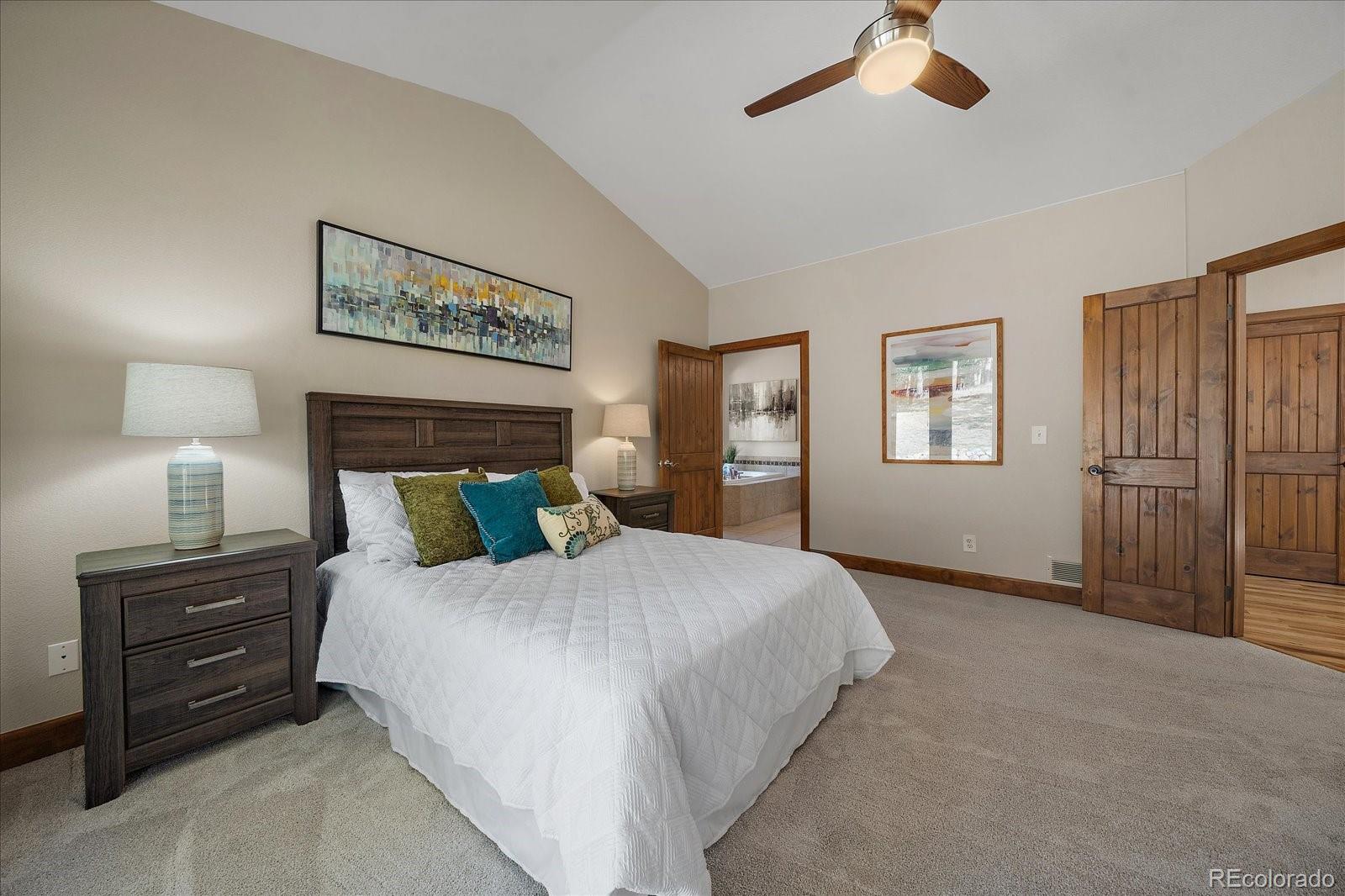 28857 Cedar Circle Evergreen, CO 80439 - Photo 21 of 50 a bedroom with a bed and a lamp on dresser