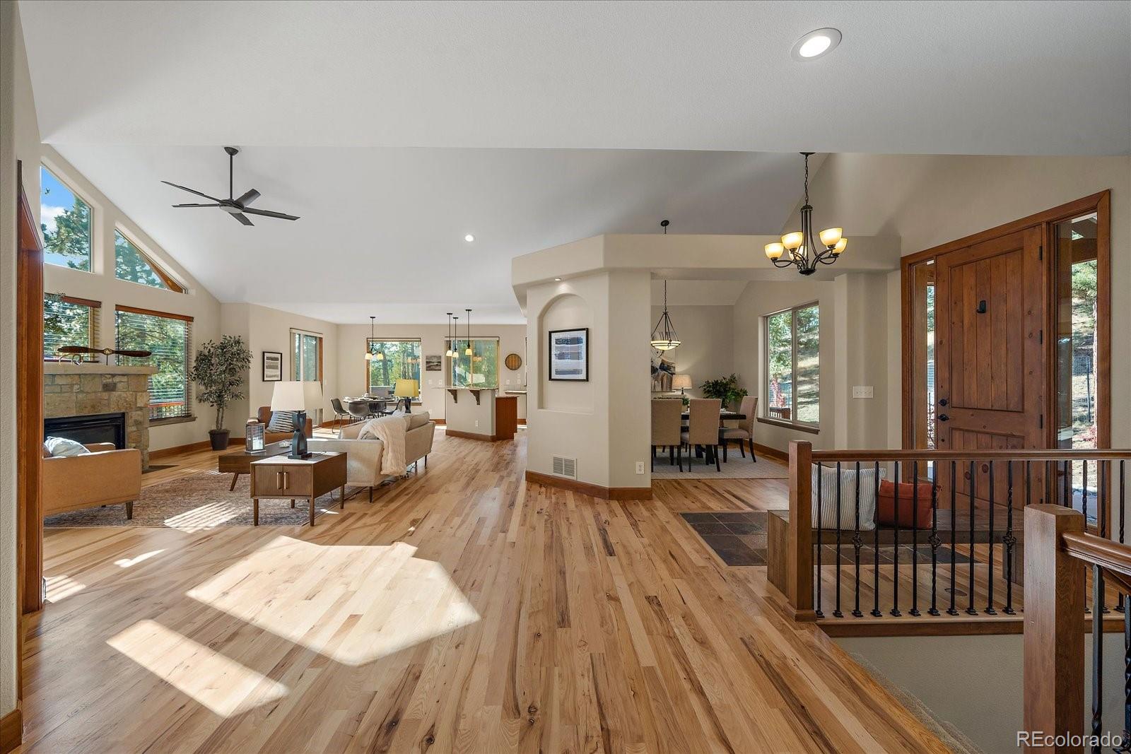 28857 Cedar Circle Evergreen, CO 80439 - Photo 7 of 50 a living room with furniture a chandelier and wooden floor