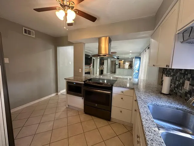 a kitchen with stainless steel appliances granite countertop a stove a sink and a refrigerator