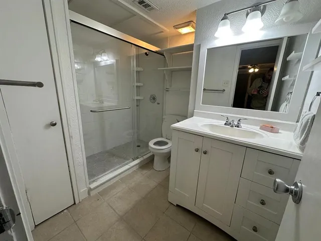 a bathroom with a shower sink and mirror
