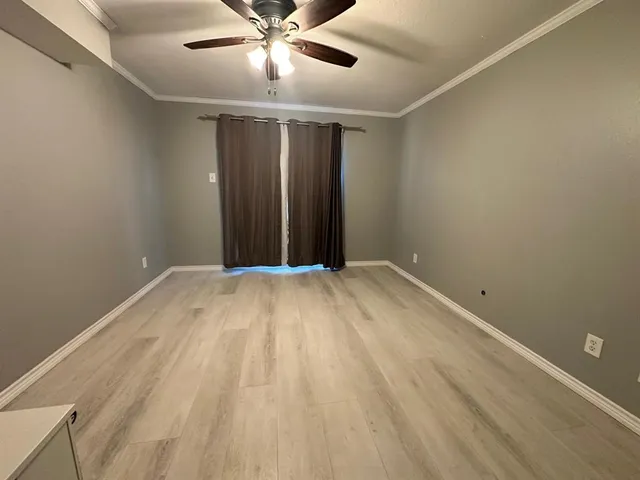 an empty room with a ceiling fan and carpet