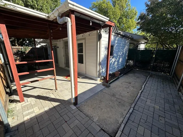 a view of backyard with large trees and a barn