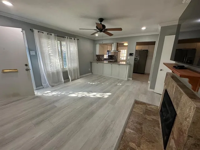 a view of a kitchen with refrigerator and wooden floor