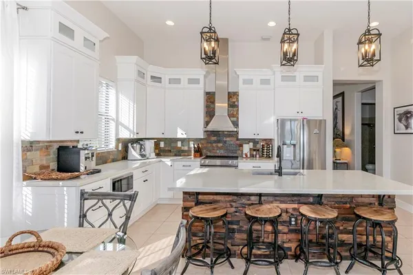 a large kitchen with granite countertop a stove a sink a dining table and chairs