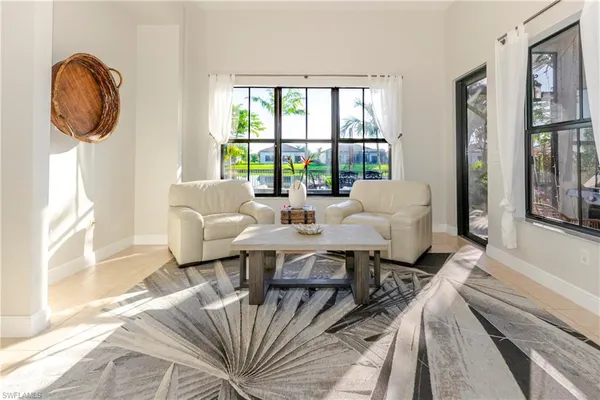a living room with furniture a large window and a chandelier