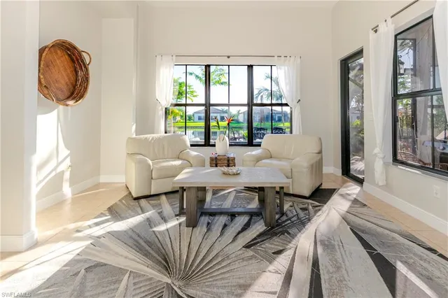 a living room with furniture a large window and a chandelier