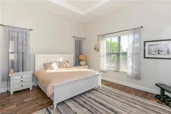 a large white bed sitting in a bedroom next to a window