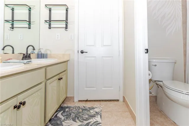 a bathroom with a sink and mirror with toilet