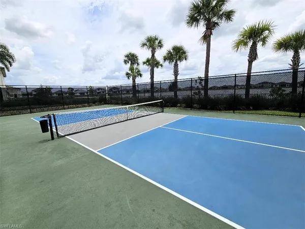 a view of a tennis court with palm trees