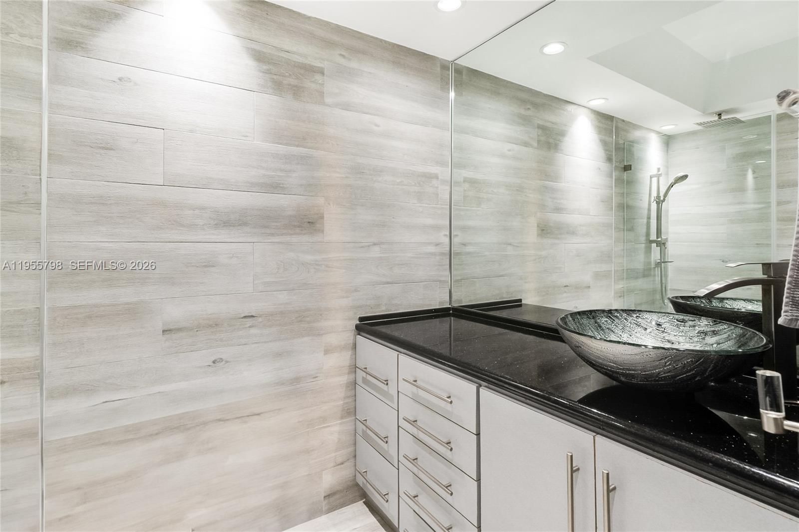 200 Southeast 15th Road, Unit 15C Miami, FL 33129 - Photo 12 of 31 a bathroom with a granite countertop sink a toilet and shower