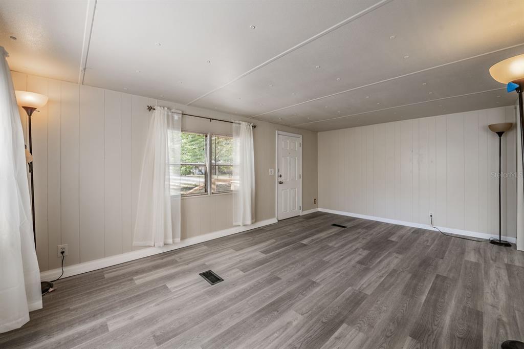 9739 Ray Street Hudson, FL 34669 - Photo 17 of 36 a view of an empty room with wooden floor and a window