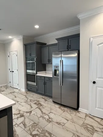 a kitchen with granite countertop a refrigerator and a sink