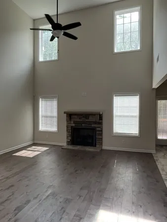 an empty room with windows and fireplace