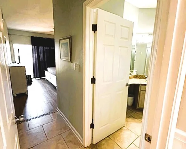 a view of a hallway with cabinets and wooden floor