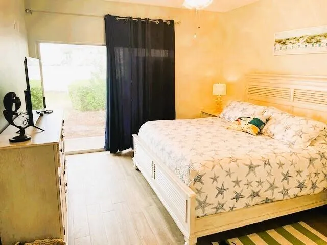 a bedroom with a bed dresser and a large window