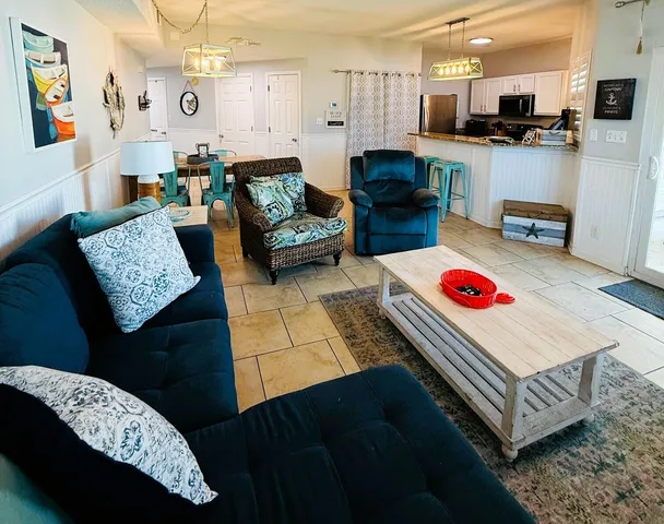 a living room with furniture and kitchen view