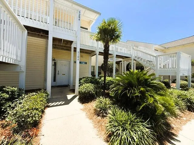 a view of a kitchen with kitchen island stainless steel appliances a sink and cabinets