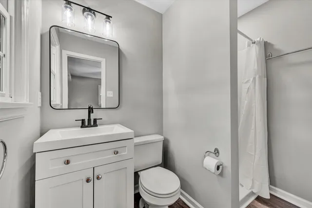 a bathroom with a toilet sink vanity and mirror