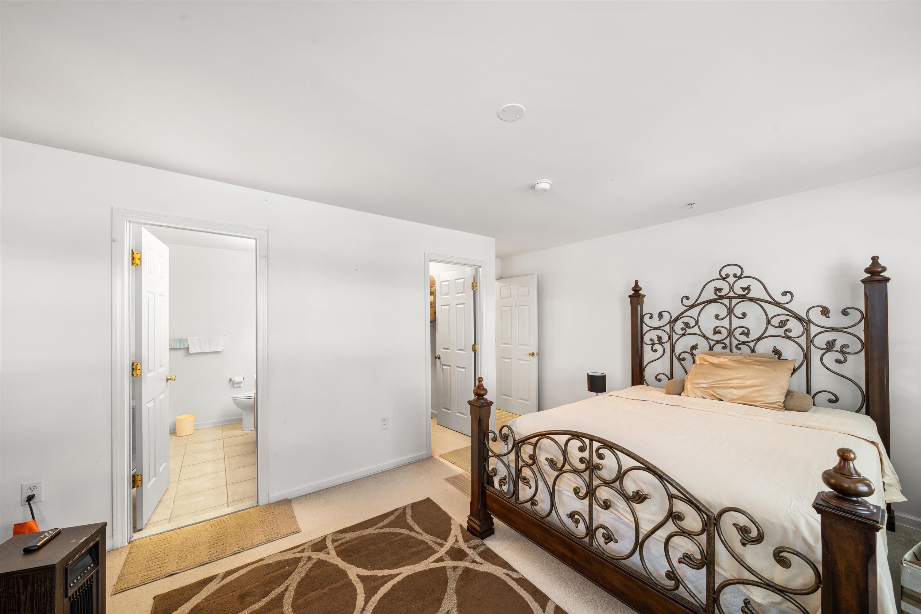 83 Windjammer Drive, Unit 83 Somers Point, NJ 08244 - Photo 23 of 33 a bedroom with a large bed and a chandelier