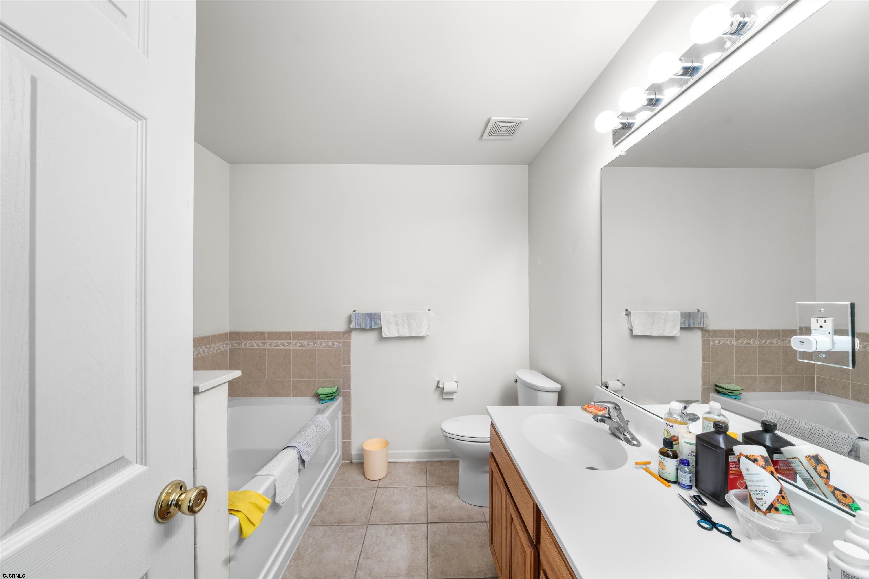 83 Windjammer Drive, Unit 83 Somers Point, NJ 08244 - Photo 29 of 33 a bathroom with a granite countertop sink a toilet and a mirror