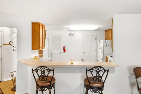 a kitchen with a refrigerator a stove top oven a sink dishwasher and wooden cabinets