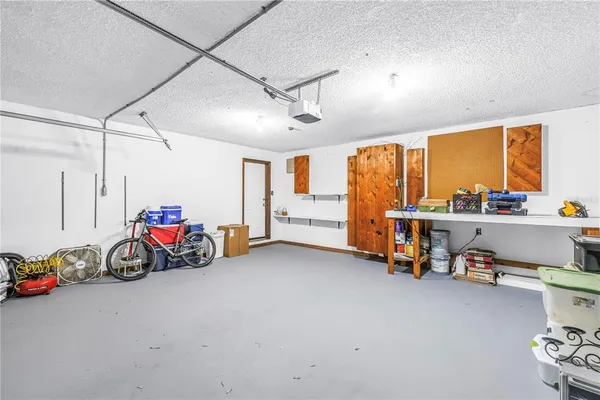 an empty room with wooden floor fireplace and windows