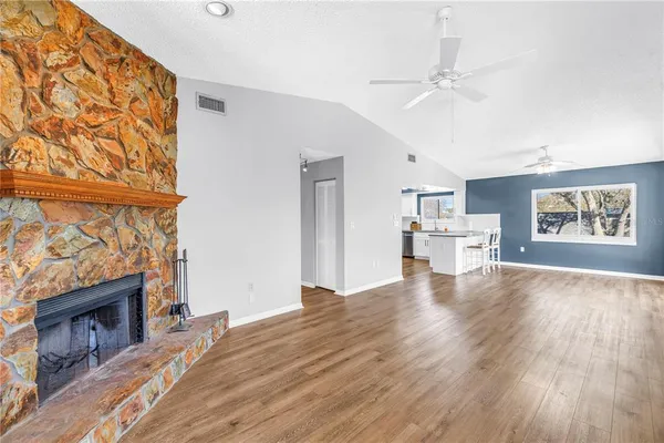 a living room with stainless steel appliances kitchen island hardwood floor and a kitchen view