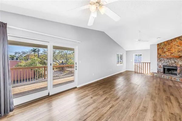 a kitchen with granite countertop a refrigerator oven a sink dishwasher and white cabinets with wooden floor