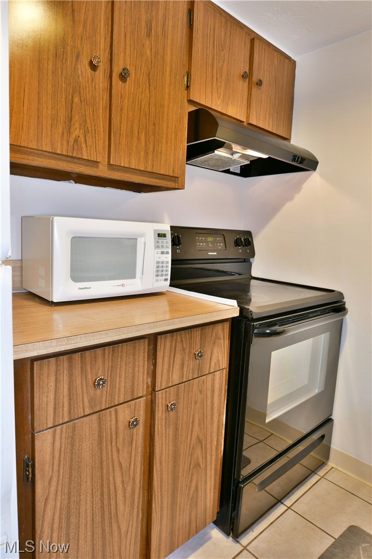 2980 North River Road Northeast, Unit E3 Warren, OH 44483 - Photo 6 of 27 Kitchen featuring black range with electric stovetop and light tile floors